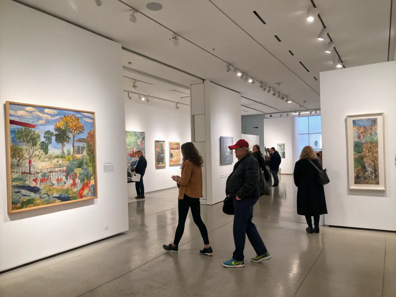 A bright, inviting photo of the Gorsline Museum’s main gallery set up for a new art exhibition, with visitors admiring paintings and a curator giving a tour.